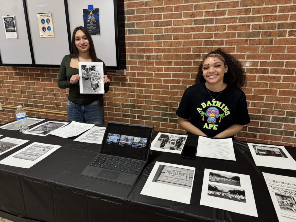 Two female students show off news clippings from the Great Migration
