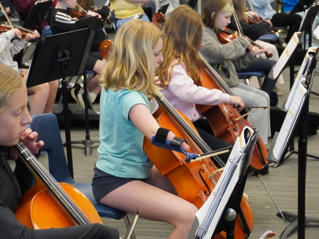 Fifth-grader Kendall Heiss plays the cello using a 3D-pritned assistance device on her bow